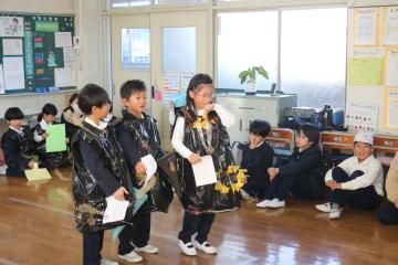 教室内でみんなに服を見てもらっている児童たちの様子