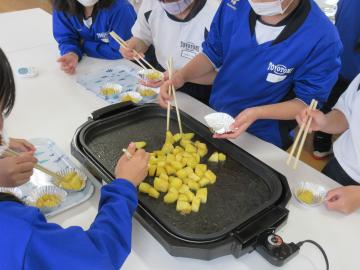 完成した大学芋をカップに盛り付けている様子