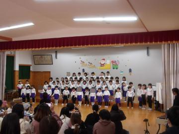 遊戯室内で園児たちがみんなで歌を歌う様子