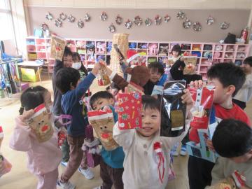 室内でブーツにプレゼントが入っていて喜ぶ幼児たちの様子