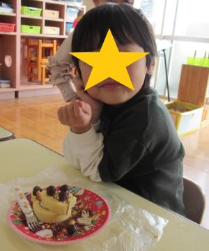 自分で飾り付けたケーキと一緒に記念撮影する子ども2