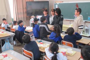 給食委員が各クラスにケーキを届けている様子