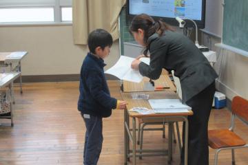 児童が通知表の説明を受けている様子