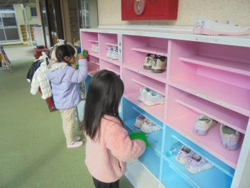 幼児が靴箱を掃除している場面