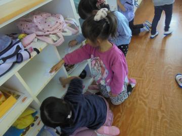 幼児が棚を掃除している場面