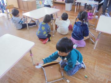 幼児が椅子を掃除している場面
