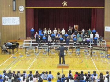 体育館の壇上で4年生が斉唱する様子