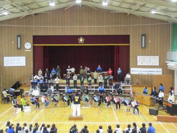 体育館の壇上で6年生が合奏する様子