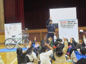 体育館で警察官の方から自転車の安全な乗り方について教えていただいている参加者の様子