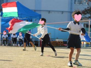 園庭で園児たちがカラーガードをしている様子