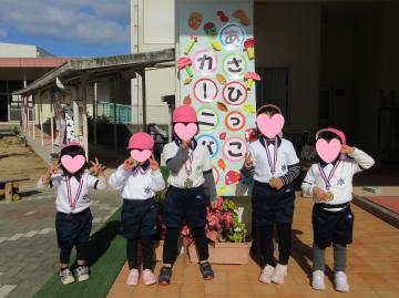 4歳児たちの園舎看板前での記念写真