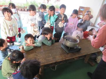 びわの葉と枝を煮出している様子を見守る幼児