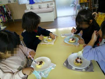 参加者たちが机の上のクリスマスケーキを食べている様子