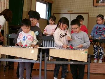 鉄琴の演奏を教える5歳児