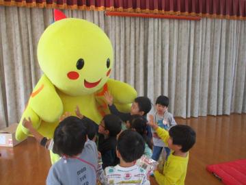 遊戯室内ではばタンの周りに集まって着ぐるみを触る子供たち