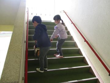 階段をほうきで掃く子供