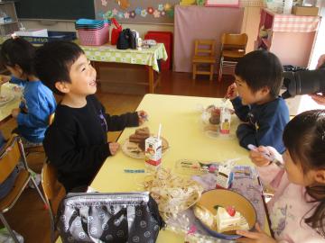 室内でケーキを嬉しそうに食べる子供たち