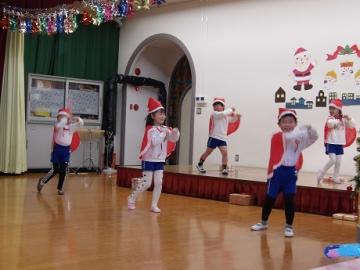 幼児がサンタの服を着てダンスをしている姿