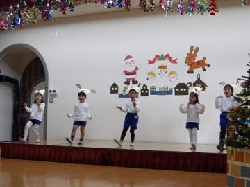 幼児がトナカイの帽子を被ってクリスマスソングを歌う様子