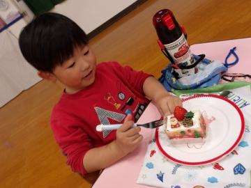 幼児がクリスマスケーキを食べる様子