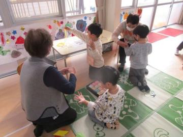 室内であやとりをしている園児たちの様子