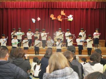 遊戯室内で鍵盤ハーモニカを吹いている園児たちの様子