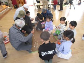 室内でコマ遊びをしている園児たちの様子