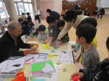 室内で折り紙遊びをしている園児たちの様子
