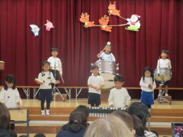 遊戯室内で線路は続くよどこまでもの合奏をしている園児たちの様子