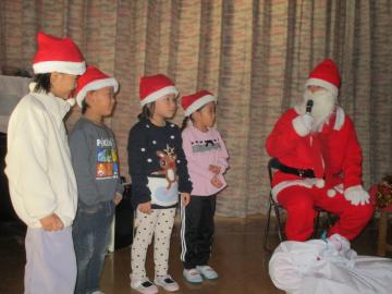 室内で園児がサンタさんに質問をしているところ