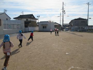 園庭で園児たちがそりの跡を走っている様子