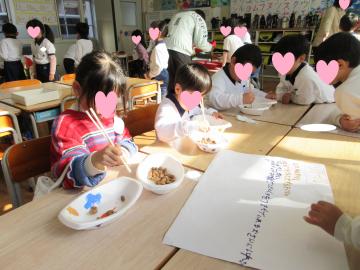 室内で園児たちがドングリ掴みをしている様子