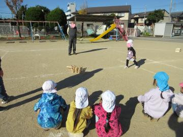 園庭で園児たちがモルックでチーム対決をしている様子