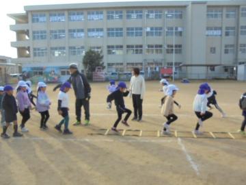 校庭でウォーミングアップをしている園児たちの様子