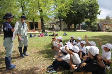 動物園で職員さんから説明を聴く児童たちの様子