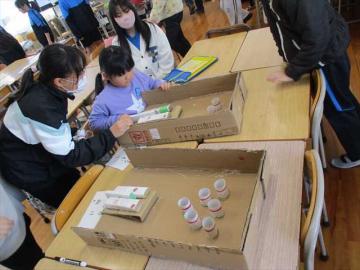 会場内で6年生が下級生にやさしく接客している様子