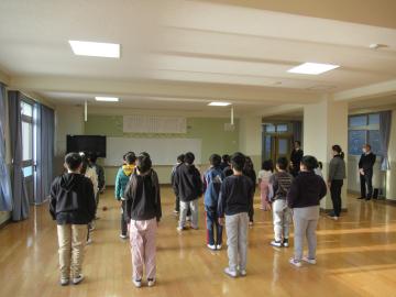 元気よく校歌を歌う児童の後ろ姿