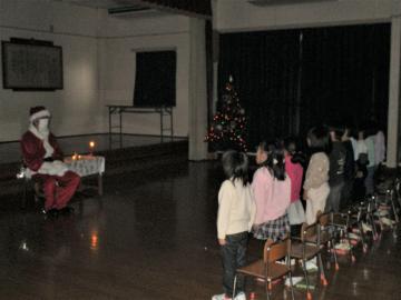 遊戯室でキャンドルサービスに参加する園児たちの様子