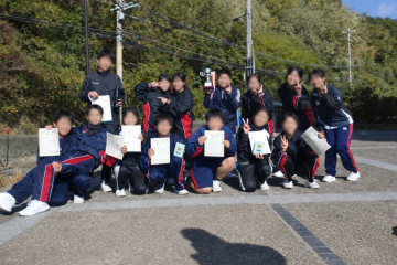 表彰式でもらった表彰状を手にもって、2列に並んで撮影をする3年生です。