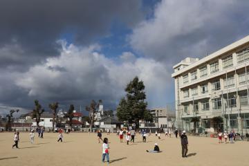 中間休みに運動場で遊ぶたくさんの児童の様子