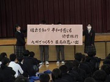 体育館の壇上前でスローガンを書いた紙を掲げる実行委員の様子