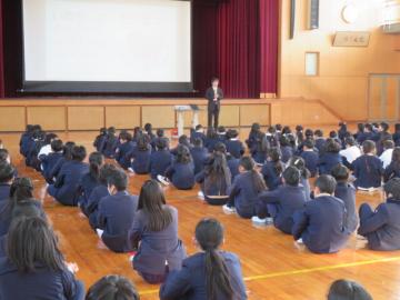 体育館内で1月の月目標についての話を聞く全校生の別の角度の画像