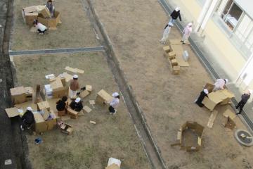 中庭で2年生が段ボールを使って作品を作っている様子