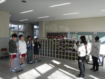 整美委員が下足場で掃除の仕方を撮影しているところ