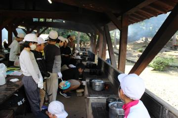 5年生が班単位で準備して竈で鍋や飯盒を火にかけている様子