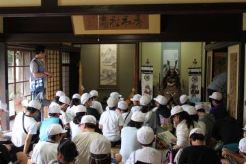 6年生が郷土史跡訪問でゴール地点になった誠塾でどのような役割を担っていたか話を聞く前の様子