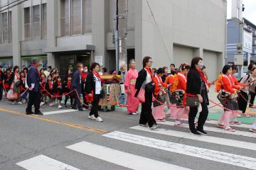 新在家地区子ども部の児童が流し連として楽器を弾きながら移動する様子