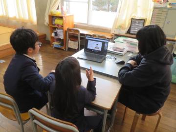 教室で席に座ったみつばち教室の生徒がテレビ画面に映る先生クイズに答えるようす