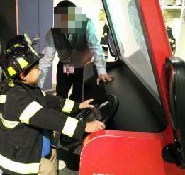 園児がミニ消防車を運転体験している様子