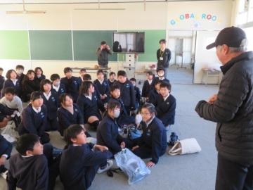 教室内で干支のキーホルダーを児童たちにプレゼントくださる長寿会副会長の様子